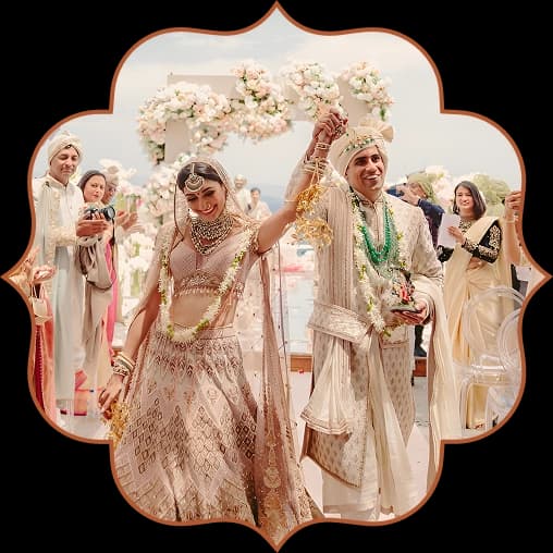 Bride and groom raising their varmala garlands