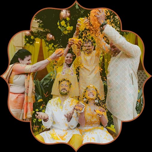 Family showering the couple with marigold petals at their haldi